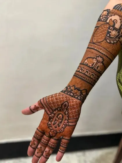 A classic bridal design with intricate details covering the hand and arm.
