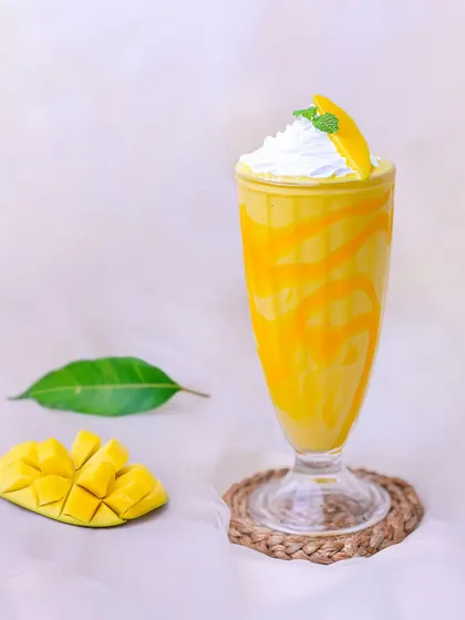 Beat the heat with our creamy and refreshing Mango Milkshake, made with ripe mangoes and topped with whipped cream.