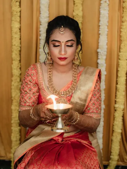 For Dr. Pooja's bangle ceremony, we went for a classic and elegant look. The makeup features a defined eye and a bold red lip, perfectly matching her beautiful silk saree and traditional gold jewellery.