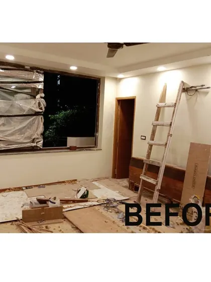 A bedroom renovation in its initial stages. The room has been cleared, and the windows are covered as we prepare for electrical work, painting, and furniture installation.