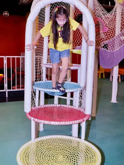 A young guest navigates the colorful, multi-level climbing tower.