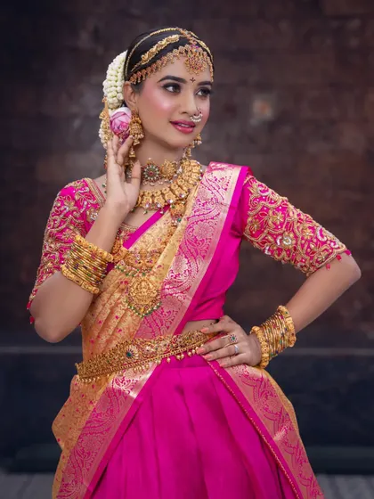 A beautiful half-saree look perfect for an engagement or pre-wedding function. The vibrant pink and gold combination is celebratory, and the makeup is kept fresh and glowing.
