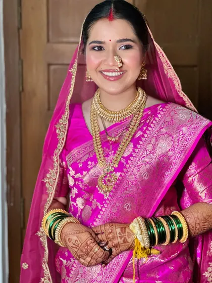 A modern Maharashtrian bride in all her glory. I loved creating this look, balancing the vibrant pink Banarasi silk with radiant skin and traditional gold jewelry for a timeless yet fresh feel.