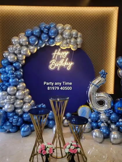 A stylish 6-month birthday celebration with a royal blue and silver balloon arch against a dark blue backdrop.
