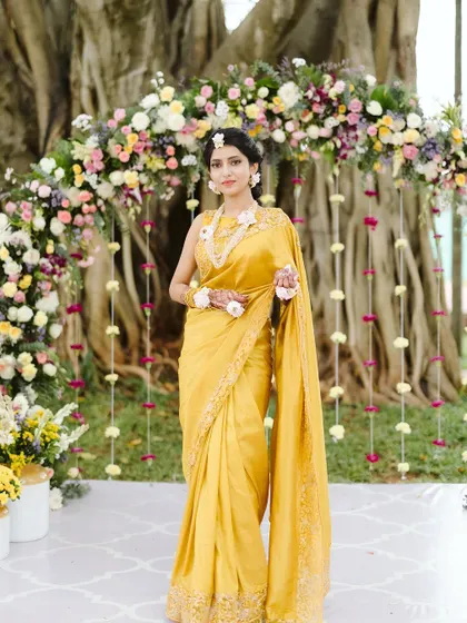 The bride looked like a dream at her Haldi. The soft, pastel floral arch we created around the tree's natural frame was the perfect backdrop for her radiant yellow saree.