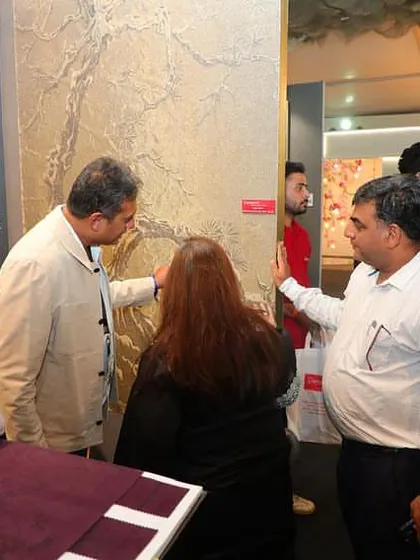 Our founder discussing a textured wallcovering with clients at our booth. We provide expert guidance to help you navigate our extensive collections and find the perfect fit for your project.