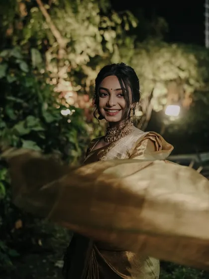 A dynamic portrait of the bride-to-be at night, with the flowing fabric of her saree creating a sense of movement and joy.