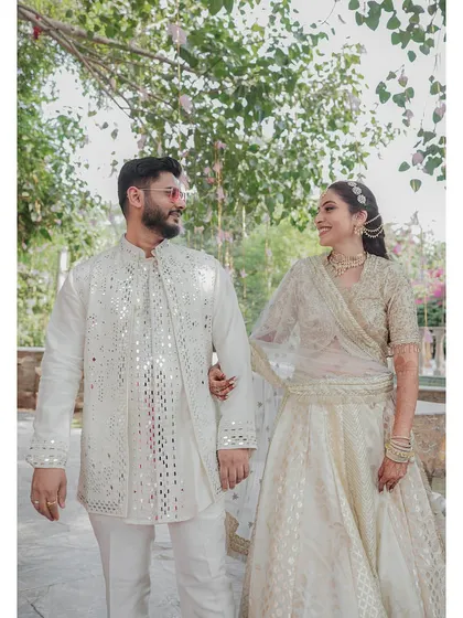 A happy, candid moment between the couple, their smiles and coordinated outfits reflecting the joy of their celebration.