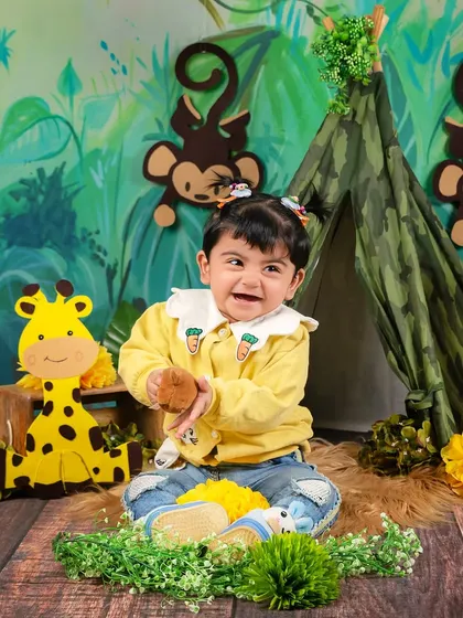 A moment of pure joy as a baby girl laughs and claps her hands in the middle of her jungle adventure setup.