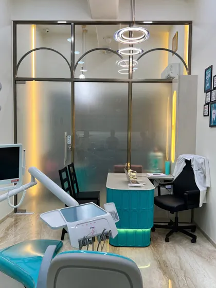 A view from the treatment chair towards the doctor's consultation cabin. The frosted glass partition creates a visual separation of spaces while ensuring the overall clinic interior feels connected and spacious.