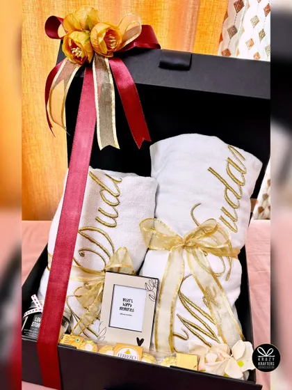A grand wedding hamper with personalized 'Mr & Mrs' towels embroidered in gold, Ferrero Rocher chocolates, and a mini photo frame.