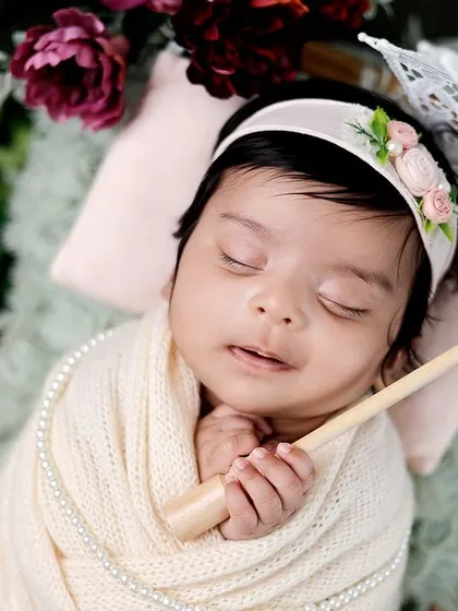 A close-up of the baby with the parasol, showing their sweet sleeping face and the delicate details of the setup.