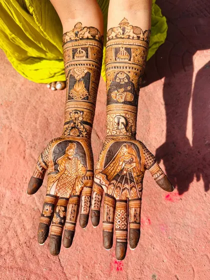This bridal mehendi tells a story with figures representing the couple, the sacred fire (agni), and other important symbols from their lives, all brought together in a beautiful design.