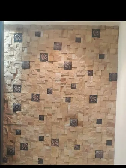 This feature wall combines natural stacked stone with interspersed decorative metal tiles. This mix of rustic stone and ornate metal creates a unique and personalized look for an interior space.