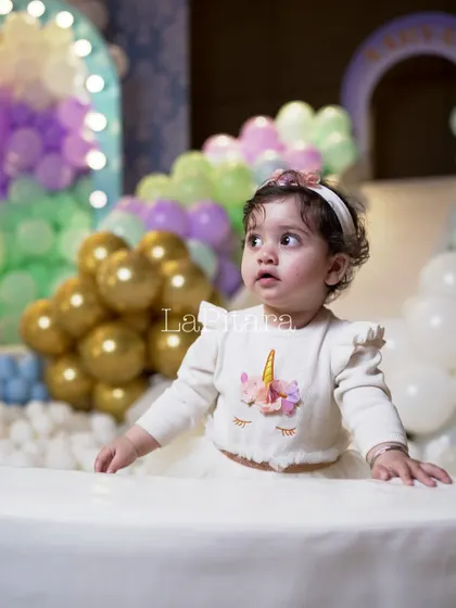 A sweet moment with the birthday girl at her carnival-themed party, sitting in a ball pit that was part of the fun and games.