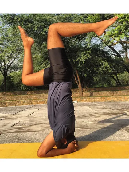 This dynamic leg variation in Sirsasana (Headstand) shows the playful side of yoga. Once you have a stable foundation, you can explore movement and challenge your balance in new ways.