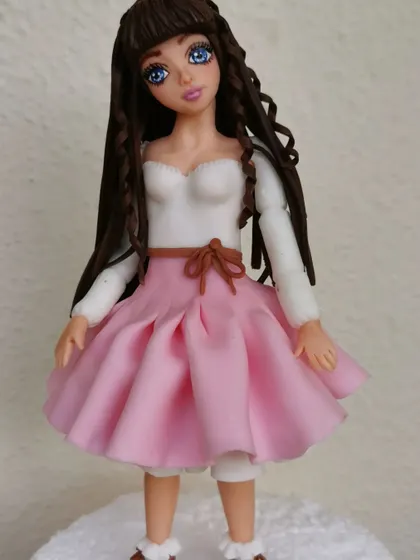 A close-up of the fondant doll I made during my training. I learned so much about sculpting faces, creating hair, and making delicate clothing from fondant.