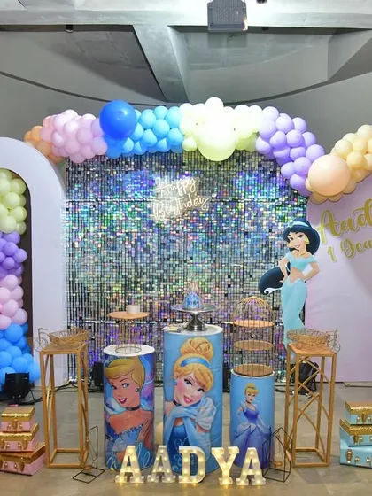 Here is another angle of the princess-themed decor, showing the full backdrop with the balloon arch and the milestone board on an easel, creating a complete and cohesive look for the party.