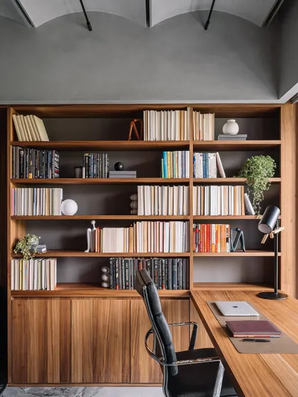 The main study room in the Vaulted Haus features a warmer palette with extensive oak veneer for the desk and bookshelves. The design creates a cozy and bright workspace with ample storage, tailored to the client's request.