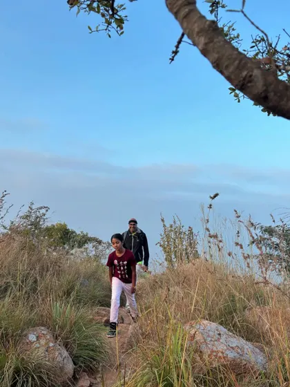 A father and son walking along a peaceful trail at Makalidurga. These quiet moments in nature are perfect for creating strong family bonds.