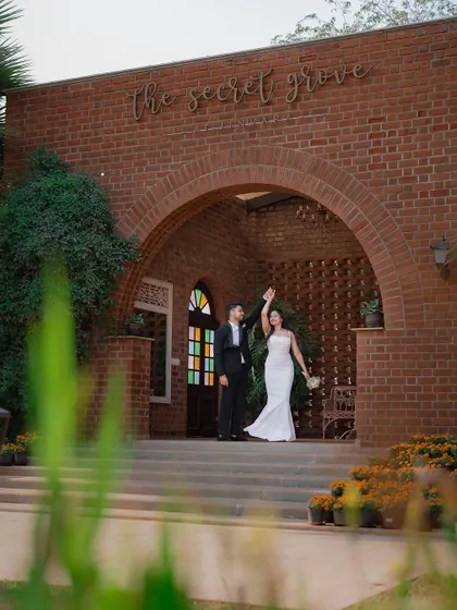 The couple waves to their guests from the entrance of "The Secret Grove," a beautiful venue for their special day.