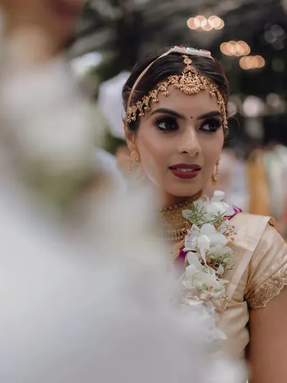This candid moment from a Muhurtham ceremony captures the beauty of a dramatic smokey eye paired with a subtle, glowing base. It's a look that is both traditional and modern, perfect for the bride who wants her eyes to do the talking.