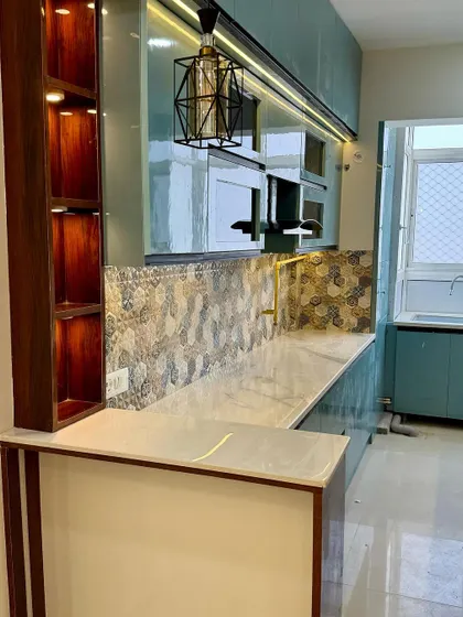 A close-up of the breakfast counter and the open wooden shelf unit, which adds warmth and a space for display.