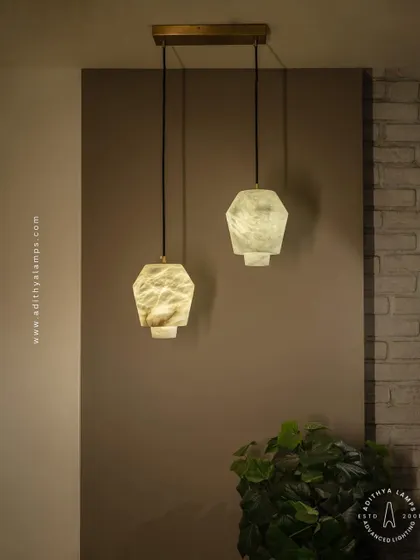 These geometric pendants are carved from a single piece of beige marble. Their unique, faceted shape and the soft glow from within make them a subtle yet elegant choice for modern kitchens or bedside lighting.