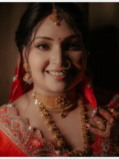 A radiant close-up of Shalini, her happy smile and traditional gold jewelry shining brightly.