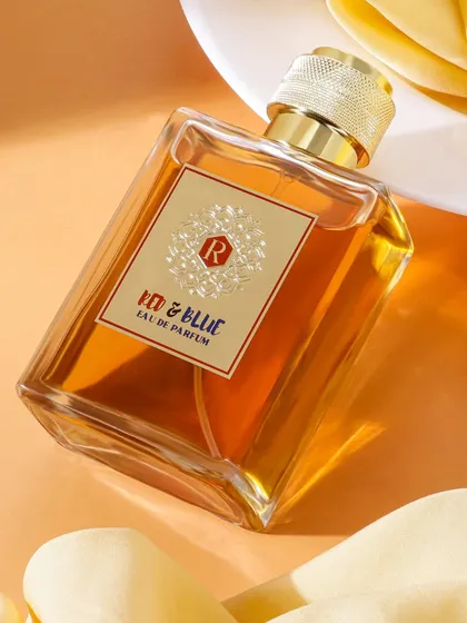 A classic luxury perfume shot, using soft fabric and warm light to create an elegant and gentle mood. The angle highlights the bottle's design and the golden hue of the fragrance.