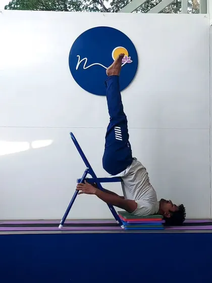 A chair provides excellent support for Sarvangasana (Shoulder Stand). This setup allows the practitioner to hold the inversion comfortably, reaping its benefits without straining the neck.