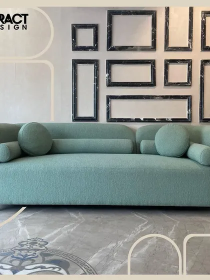 We call this the "Cloud" sofa for its soft, rounded form and dreamy comfort. Upholstered in a moss green bouclé fabric, this three-seater sofa with its bolster and round cushions is a sanctuary of relaxation.