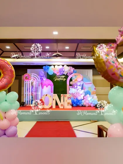 A wider view of the Candyland setup, showing the donut-themed balloon pillars that frame the stage.