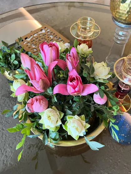 A traditional centerpiece with pink and white lotus flowers, perfect for an intimate and elegant home celebration.