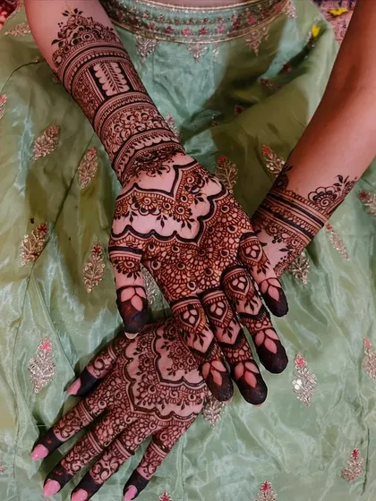 A different pose of the full bridal mehendi, showing the intricate details on the fingers and palms.