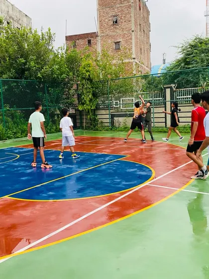 Players remain engaged and focused during a game on the wet court.