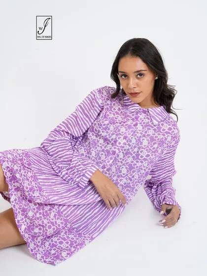 A different seated angle, providing a clear view of the dress's print and collar detail.