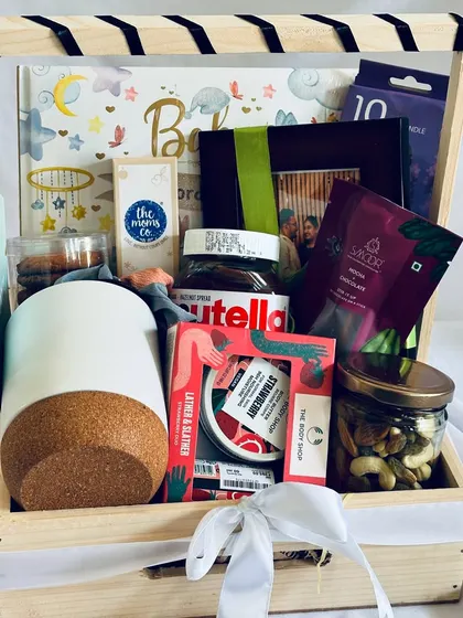 A closer look at our baby shower hamper, showcasing the curated items like Nutella, The Body Shop products, a photo frame, and essentials from The Moms Co.