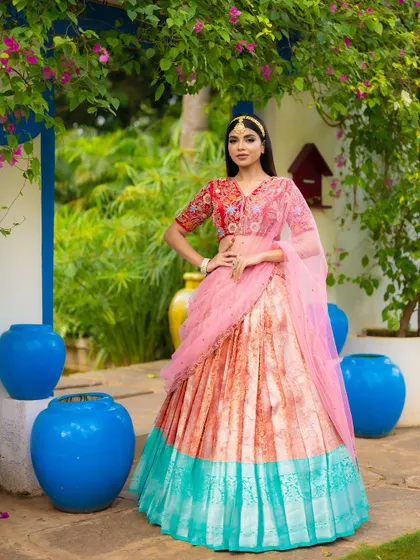 A slightly different angle of the same colorful half saree, showing the full outfit and the beautiful garden setting.