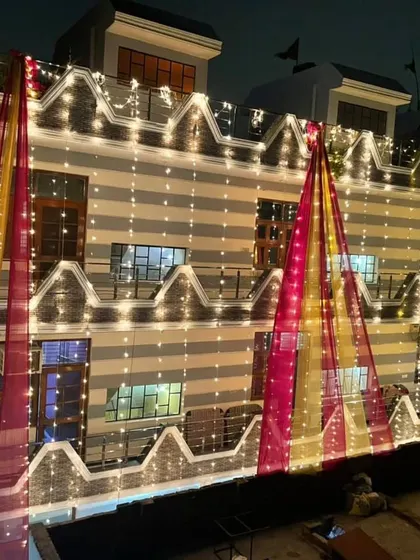 A house facade lit up for a wedding, with fairy lights creating a curtain of light over the entire building.