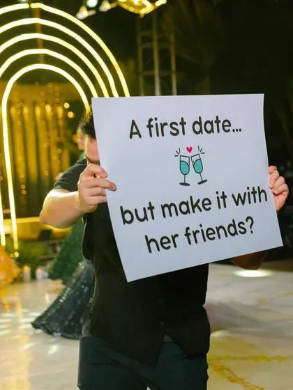 A prop sign humorously depicting their first date, adding a personal and funny touch to the sangeet narrative.