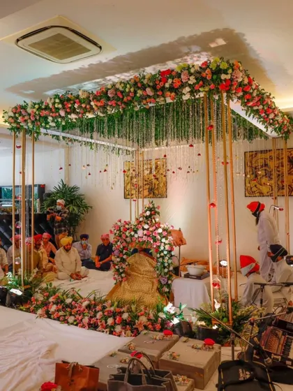 A serene and beautiful setup for a Sukhmani Sahib Path at home. I used a floral canopy with hanging strings of flowers over the main seating area to create a divine atmosphere, perfect for spiritual gatherings and blessings.