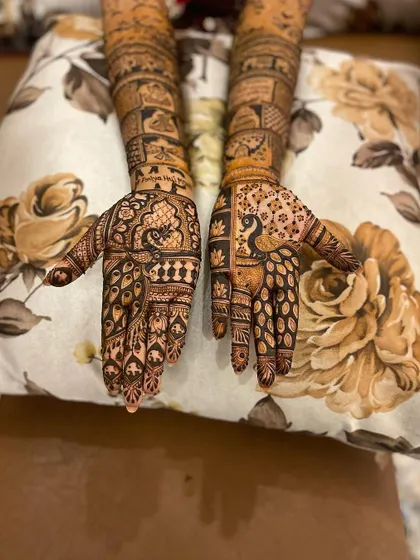 The back of the hands from a full bridal set, showcasing intricate peacock designs. I ensure the design is beautiful from every angle.