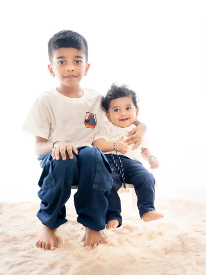 A proud big brother holds his baby brother. Sibling photoshoots are a wonderful way to document their growing relationship.