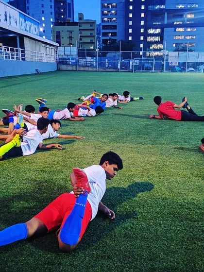 Our youth team performs essential cool-down stretches after an intense training session on the Astro Arena turf. We prioritize player safety and recovery as part of our holistic football program.