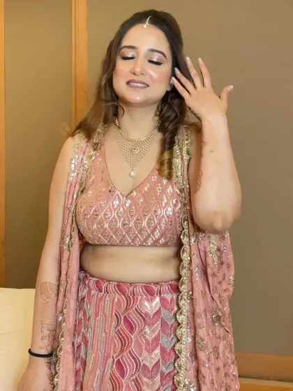 The bride showing off her hand, a playful gesture that also gives a glimpse of her Mehendi design.