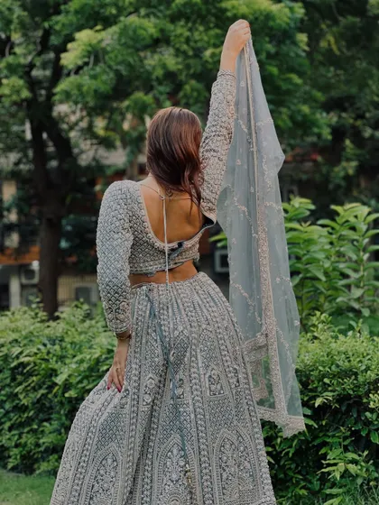 The back view of the ice-blue chikankari lehenga, showing the beautiful back design and the flow of the sheer dupatta.