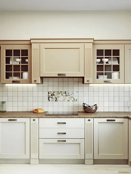 This kitchen showcases a traditional, country-style design with cream-colored shaker cabinets and a simple white tile backsplash.