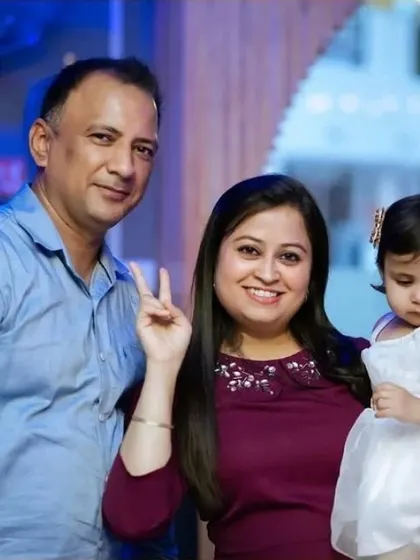 A happy family of three posing for the camera, with the mother making a peace sign.