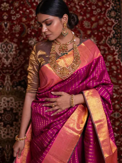 Our model exudes poise and elegance in this deep pink bridal saree, a color that signifies celebration and joy in our culture.